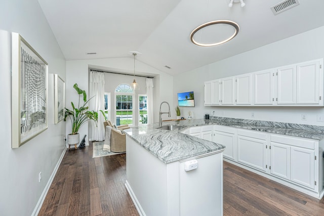 kitchen with kitchen peninsula, vaulted ceiling, sink, white cabinets, and dark hardwood / wood-style floors