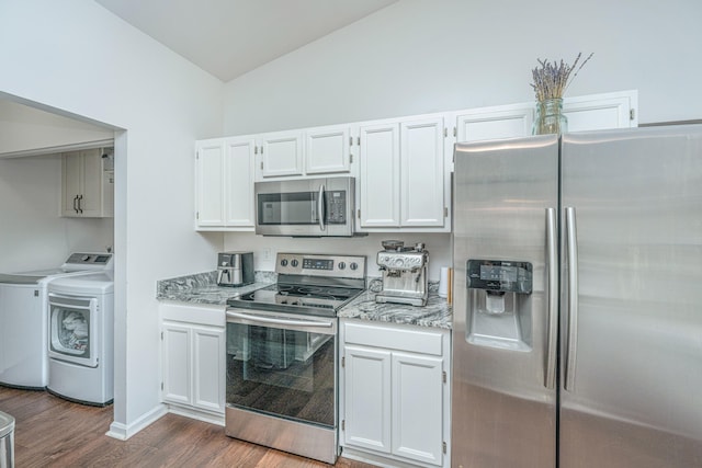 kitchen featuring lofted ceiling, dark wood-type flooring, washing machine and dryer, appliances with stainless steel finishes, and white cabinetry