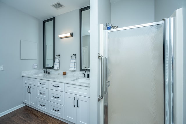 bathroom with vanity, wood-type flooring, and a shower with door