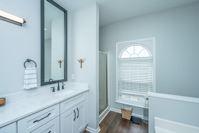 bathroom with hardwood / wood-style floors, vanity, and a shower with door