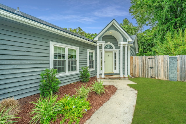 property entrance with a lawn