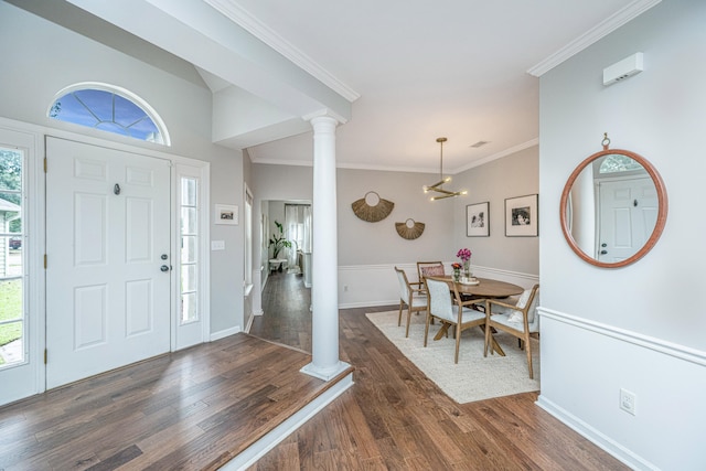 foyer entrance with ornamental molding, dark hardwood / wood-style floors, ornate columns, and a healthy amount of sunlight