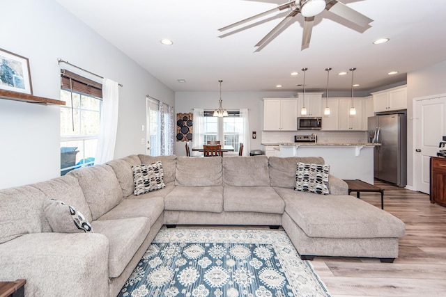 living room with ceiling fan and light hardwood / wood-style floors