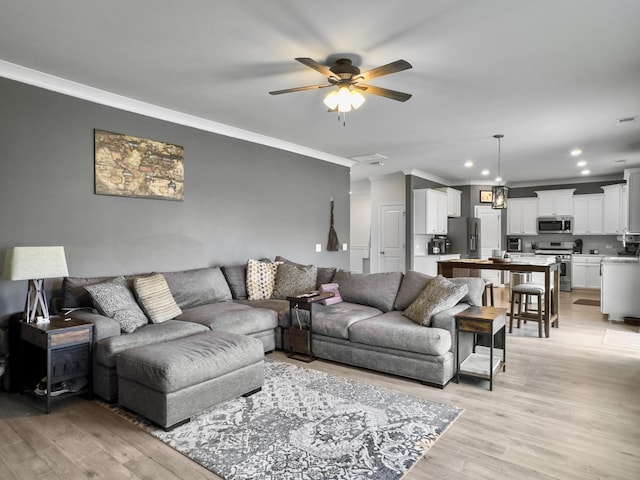 living area featuring ornamental molding, light wood-style floors, ceiling fan, and recessed lighting