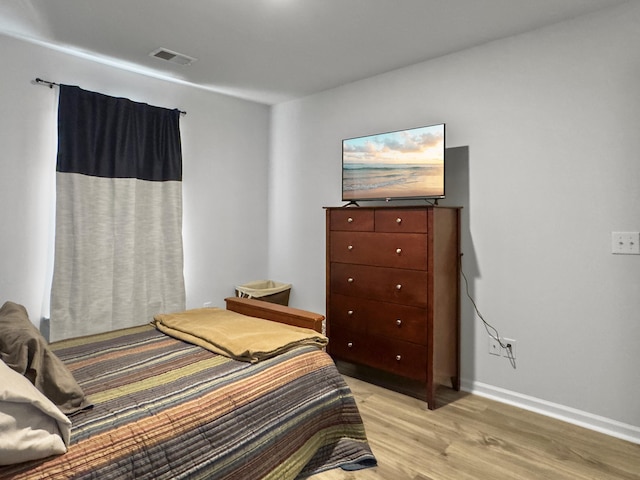 bedroom with light wood-style flooring and baseboards