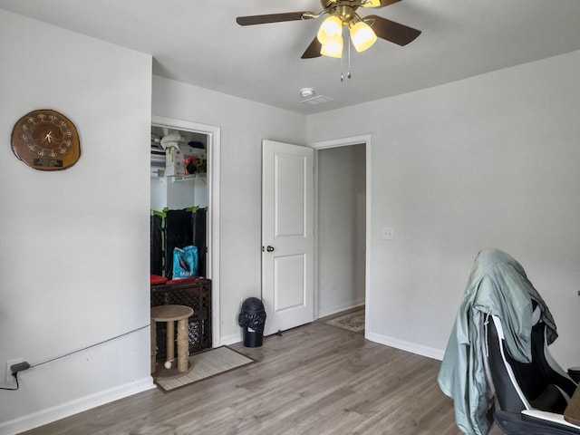 office space with a ceiling fan, wood finished floors, and baseboards