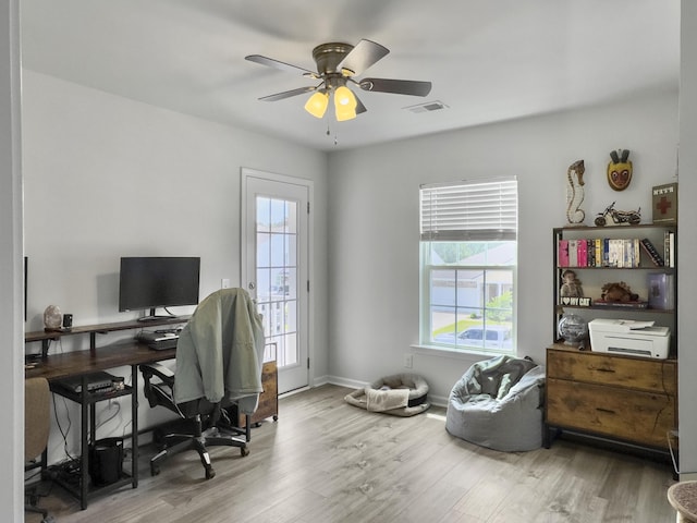 home office with healthy amount of natural light, wood finished floors, ceiling fan, and baseboards