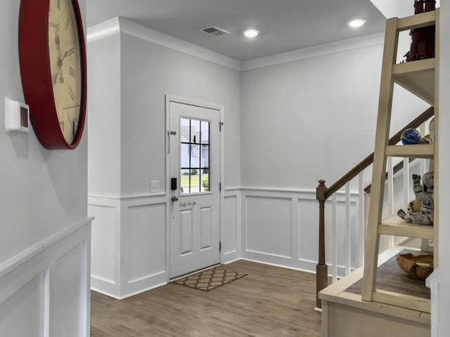 entryway with wainscoting, a decorative wall, and wood finished floors