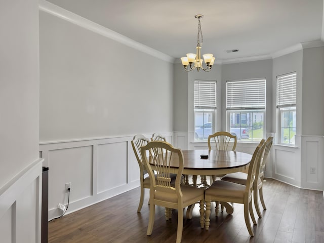 dining space with a decorative wall, a chandelier, ornamental molding, a wainscoted wall, and dark wood-style flooring