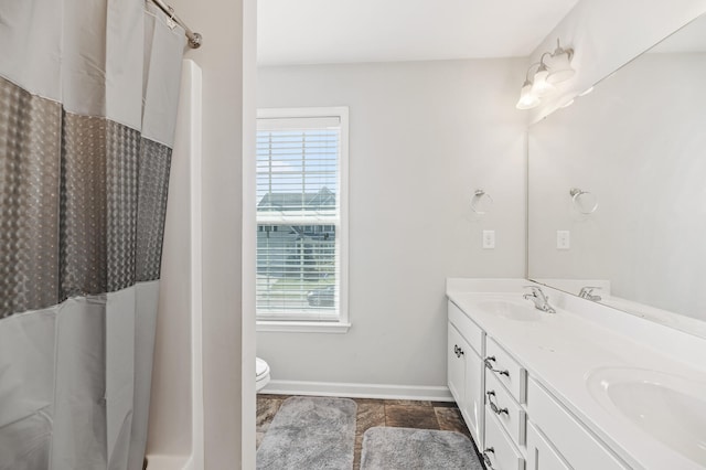 bathroom featuring vanity, curtained shower, and toilet