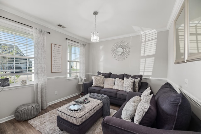 living room featuring crown molding, dark hardwood / wood-style flooring, and a notable chandelier