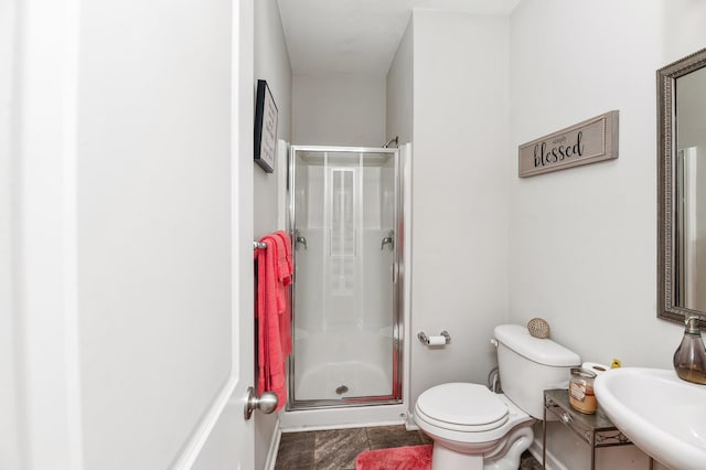 bathroom with sink, a shower with shower door, and toilet