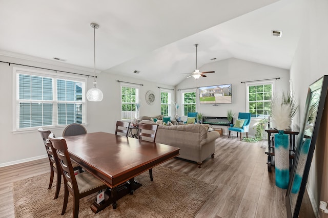 dining space with light wood-type flooring, vaulted ceiling, and ceiling fan