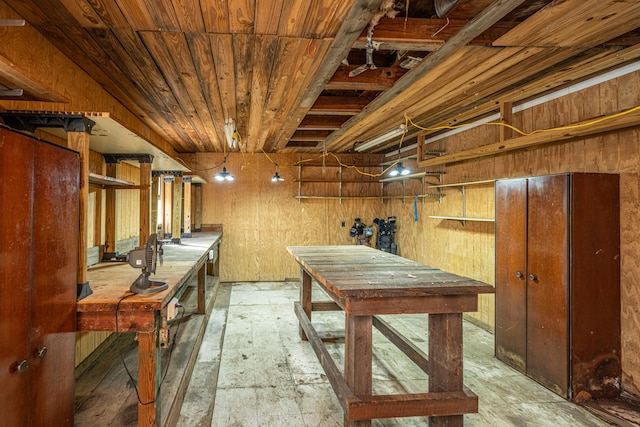 basement with a workshop area and wooden walls