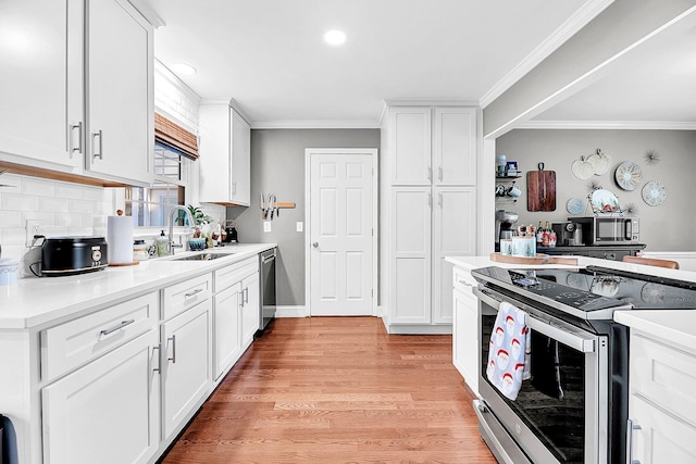 kitchen featuring light wood-type flooring, white cabinetry, sink, and appliances with stainless steel finishes