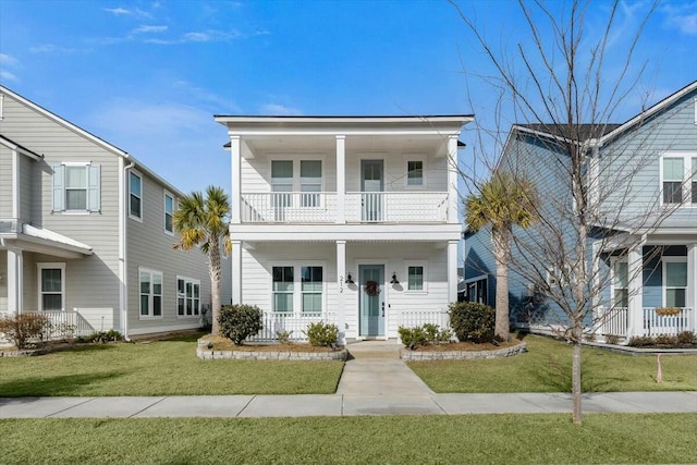 view of front facade with a balcony, a front yard, and covered porch