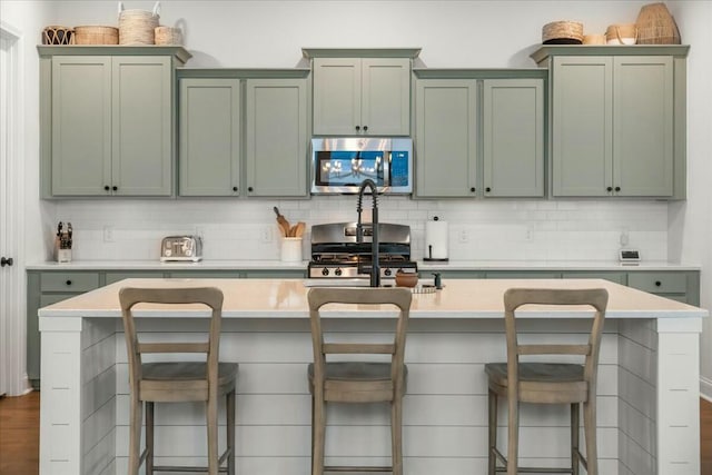 kitchen featuring decorative backsplash, a breakfast bar, and stainless steel appliances