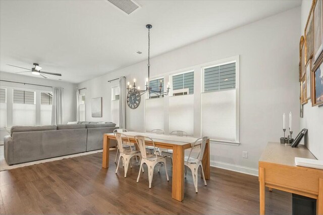 dining area featuring ceiling fan with notable chandelier and dark hardwood / wood-style floors