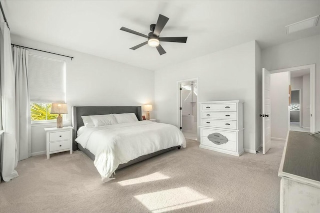 carpeted bedroom featuring ceiling fan and ensuite bath