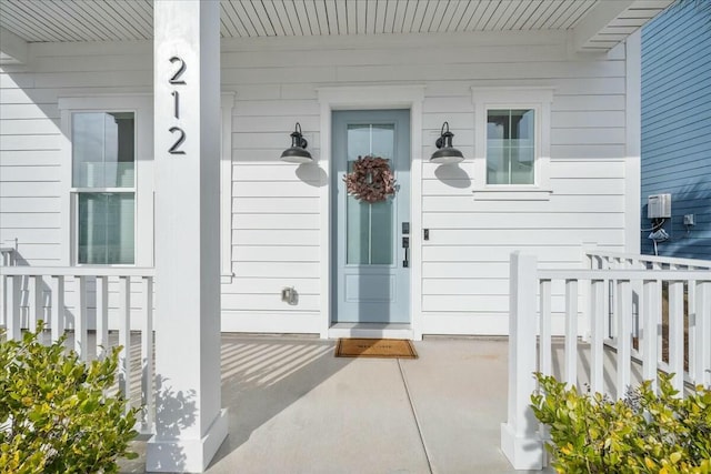 view of exterior entry featuring covered porch