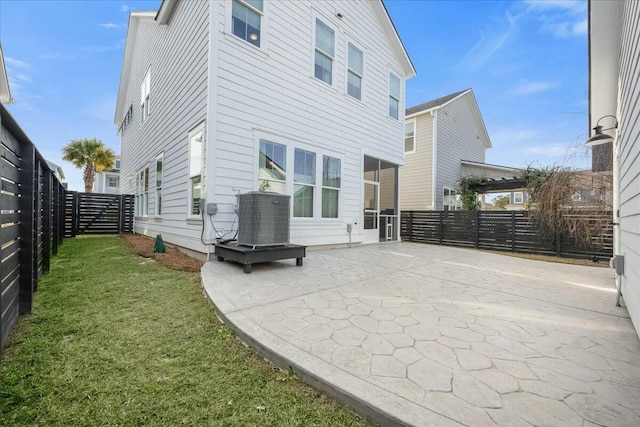 back of house featuring central AC unit, a patio area, and a yard