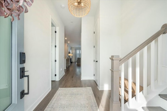 corridor featuring dark hardwood / wood-style flooring and a chandelier