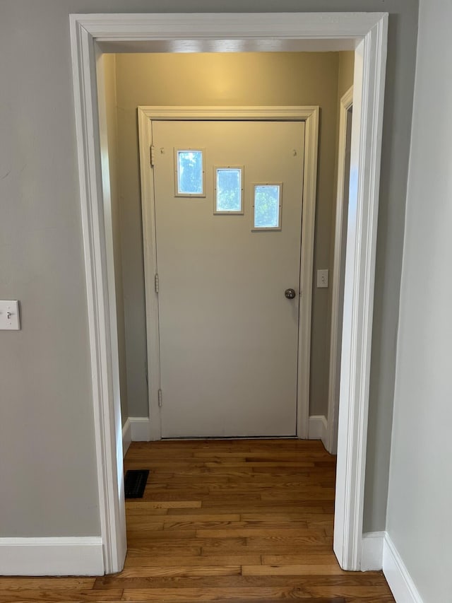 interior space with visible vents, baseboards, and wood finished floors