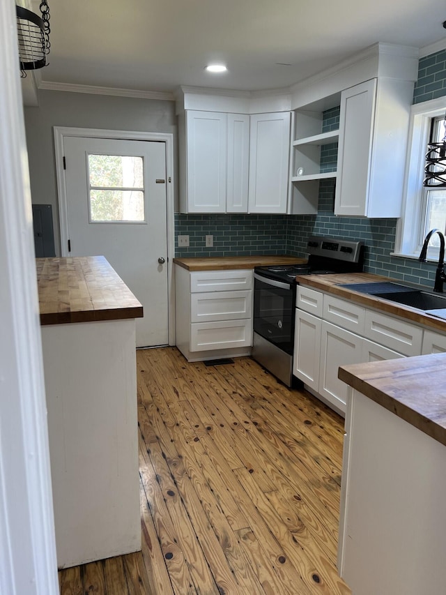 kitchen with open shelves, white cabinetry, a sink, wood counters, and stainless steel electric range