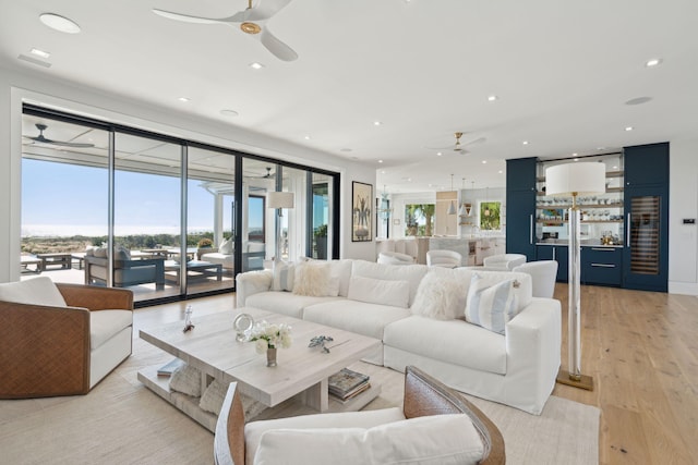 living room featuring light hardwood / wood-style flooring and ceiling fan