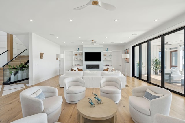 living room featuring light hardwood / wood-style flooring and ceiling fan