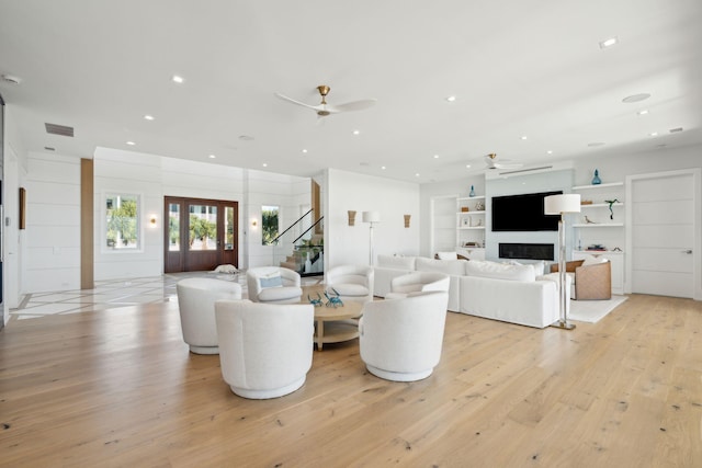 living room with ceiling fan and light wood-type flooring