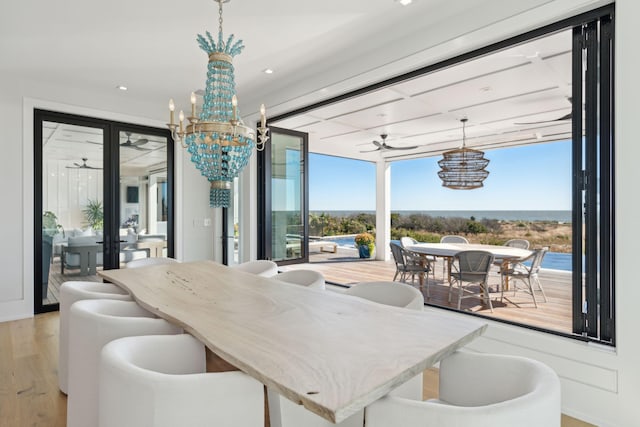 dining room featuring ceiling fan with notable chandelier, light hardwood / wood-style flooring, and a wealth of natural light