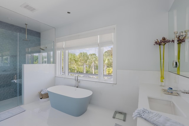 bathroom with tile patterned floors, vanity, tile walls, and independent shower and bath