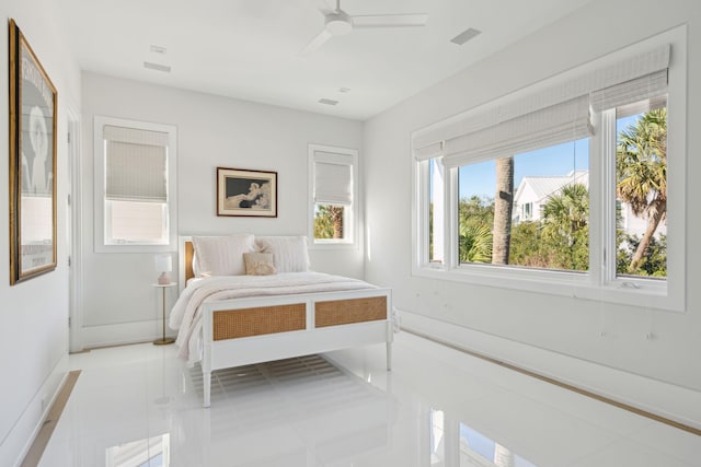 tiled bedroom with ceiling fan and multiple windows