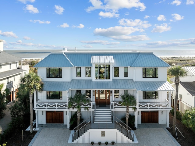 view of front of property with a water view, covered porch, and a garage