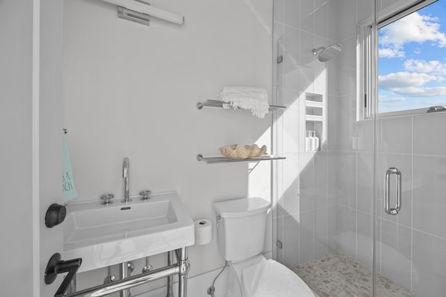 bathroom with toilet, an enclosed shower, and sink