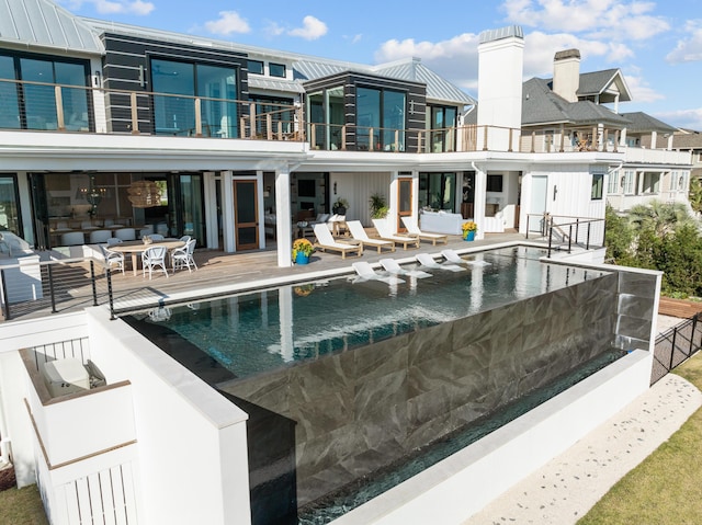 back of house with a balcony and a patio