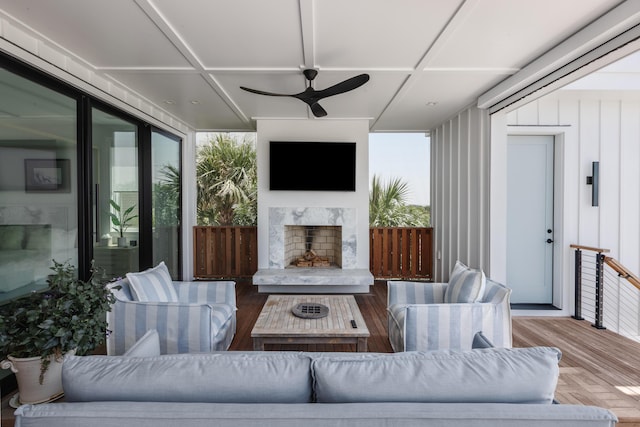 exterior space featuring an outdoor living space with a fireplace, ceiling fan, and a deck