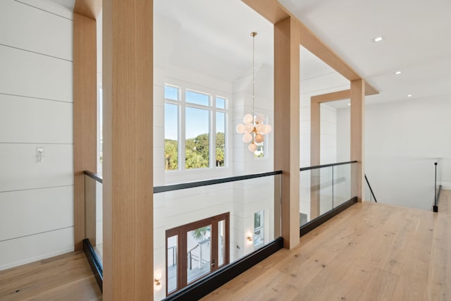 hallway featuring an inviting chandelier and light wood-type flooring