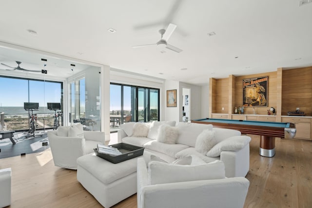 living room with ceiling fan, light hardwood / wood-style floors, and pool table