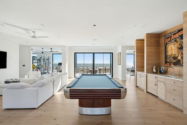 rec room with ceiling fan, sink, light hardwood / wood-style floors, and billiards