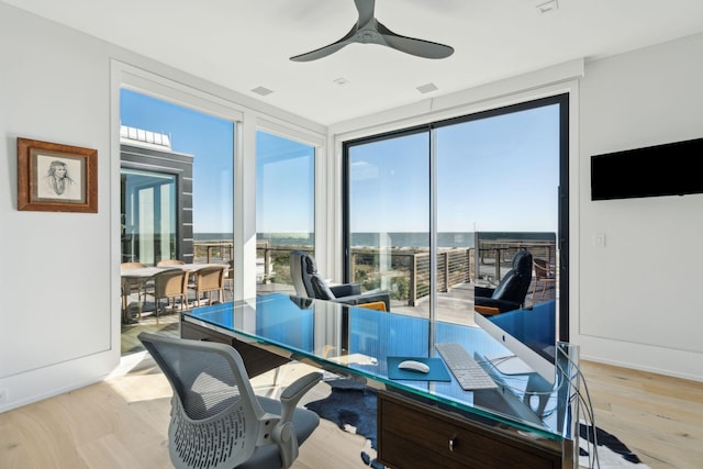 office area featuring light wood-type flooring, plenty of natural light, and ceiling fan