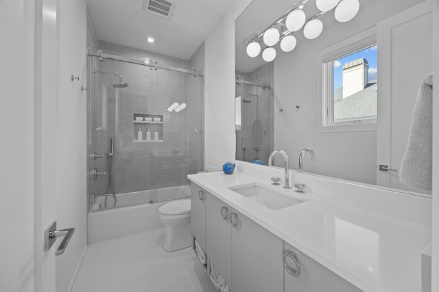 full bathroom with shower / bath combination with glass door, tile patterned flooring, vanity, and toilet