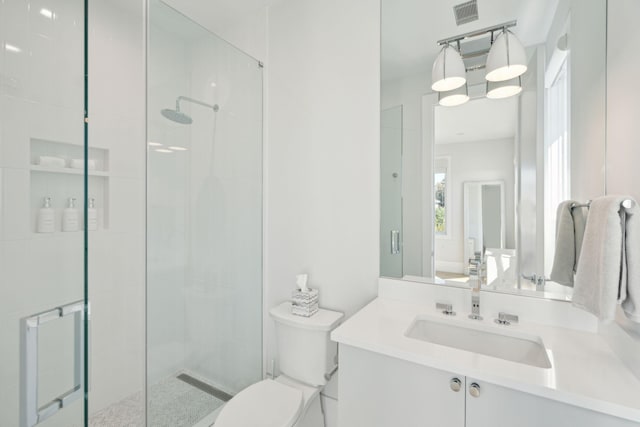 bathroom featuring vanity, toilet, and a shower with shower door