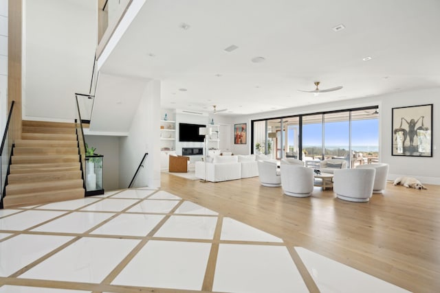 unfurnished living room featuring ceiling fan and hardwood / wood-style flooring