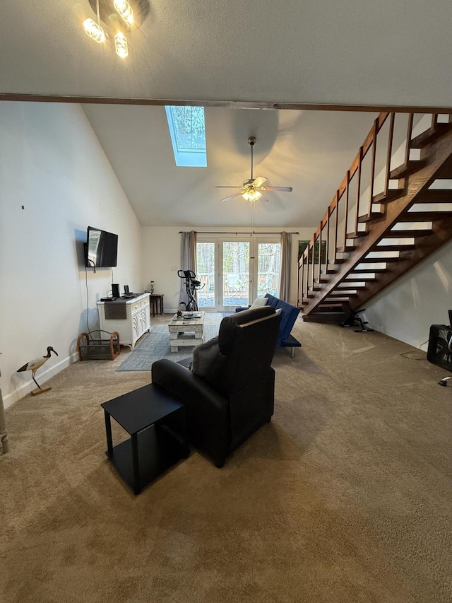 carpeted living room with ceiling fan, a textured ceiling, high vaulted ceiling, and a skylight