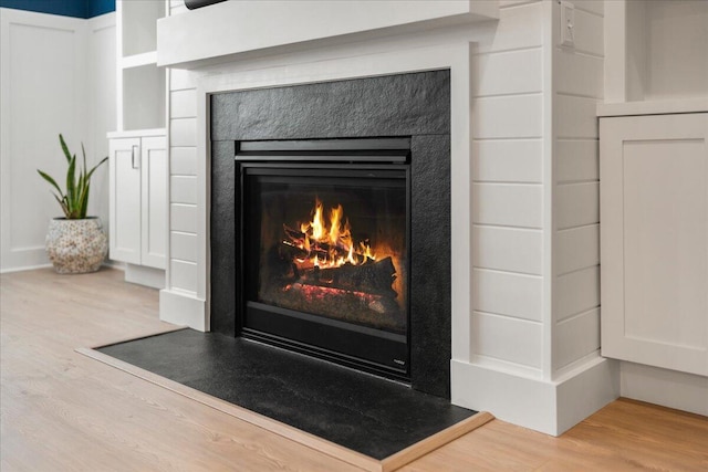 interior details featuring a lit fireplace and wood finished floors