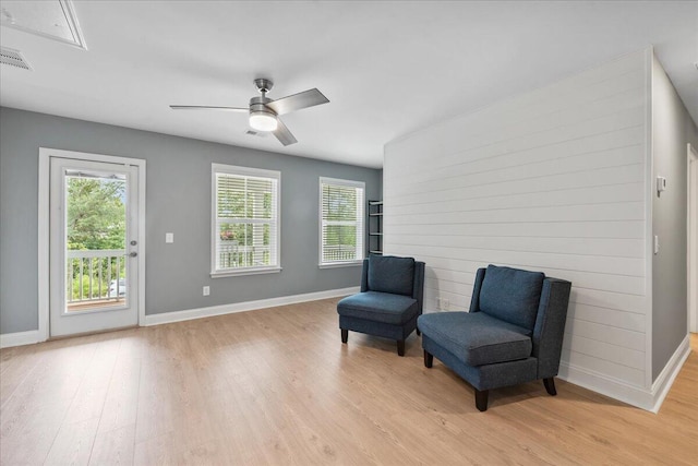 living area with visible vents, ceiling fan, light wood-style flooring, and baseboards