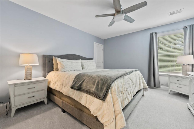 bedroom featuring a ceiling fan, light colored carpet, and visible vents