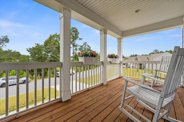 wooden terrace featuring a residential view and a yard